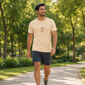 Smiling man walking a park path in a 1 Moore Rep sand sleeve print tee with a small red 方 MR chest logo