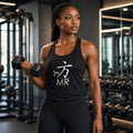 Woman lifting a dumbbell in a gym wearing a 1 Moore Rep black racerback tank with the white 方 MR logo